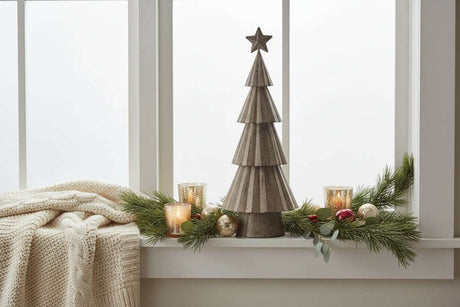 Rustic Bough Tree Christmas decoration on a window sill with candles and greenery