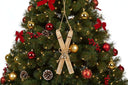 Rustic Crossed Skis Christmas bauble decoration hanging on a festive tree with red and gold ornaments