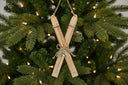 Rustic Crossed Skis Christmas bauble decoration with natural wood finish hanging on a festive tree