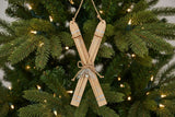 Rustic Crossed Skis Christmas bauble decoration with natural wood finish hanging on a festive tree