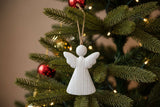 Rustic Hanging Angel Christmas bauble decoration on a festive tree with red ornaments