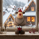 Charming Rustic Reindeer Figurine with a Red Hat and Star Decoration, Set Against a Wintery Background