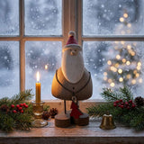 Rustic Santa decoration on a table with a candle and festive greenery for Christmas room decor