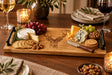 Selbrae House wooden serving tray with engraved deer design, cheese, crackers, and grapes