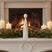 Rustic Standing Angel Decoration on a Mantle Surrounded by Candles and Pinecones for Christmas Room Decorations