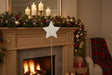Rustic Star Christmas room decoration displayed on a mantel with festive garland and candles