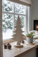 Rustic Tree decoration on a window sill with snowy backdrop and warm festive atmosphere