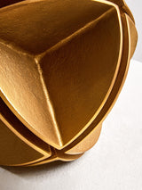 Elegant gold sculpture by Orsina with intricate geometric shapes and a smooth finish