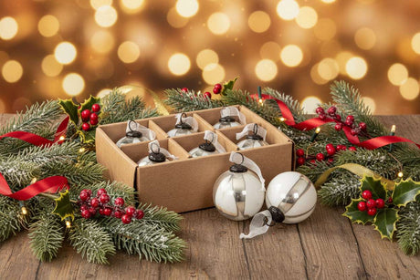 Set of Baubles in White and Silver, displayed with festive greenery and lights for Christmas decoration