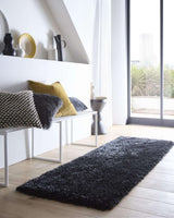 Elegant black shaggy rug placed in a modern living space with stylish decor and natural light