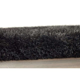 Close-up of a soft black shaggy rug with a plush texture for a cosy home decor