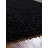 Thick black Shaggy Rug on a wooden floor, perfect for adding warmth to any room