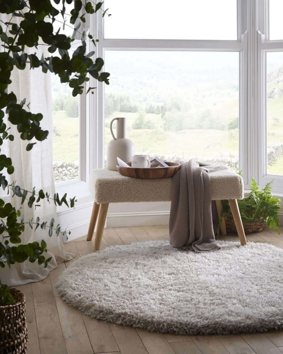 Cozy living room with a soft shaggy rug placed under a bench and natural decor elements