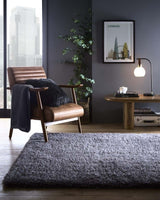 Stylish Shaggy Rug in Grey, enhancing a modern living room with a comfortable chair and contemporary decor.