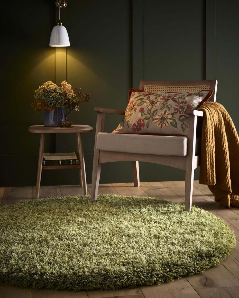 Soft green shaggy rug in a cozy living room setting with a wooden chair and warm decor