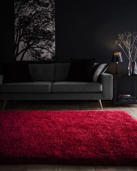 Vibrant red shaggy rug placed under a sofa in a stylish living room setting