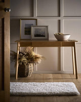 Stylish Shaggy Rug placed under a wooden console table with decor and a woven basket