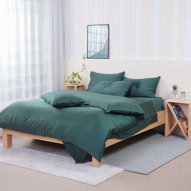 SHEET STORY Duvet Cover Set in deep green on a modern wooden bed with matching cushions