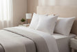 PillowPillow Goose Down Pillow set on a neatly made bed with light bedding and soft lighting