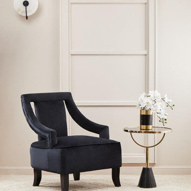 Elegant Orsina Side Table with round top, paired with a stylish armchair and decorative flowers