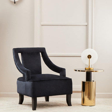Stylish Orsina Side Table with a gold base and circular top, complementing a navy upholstered chair