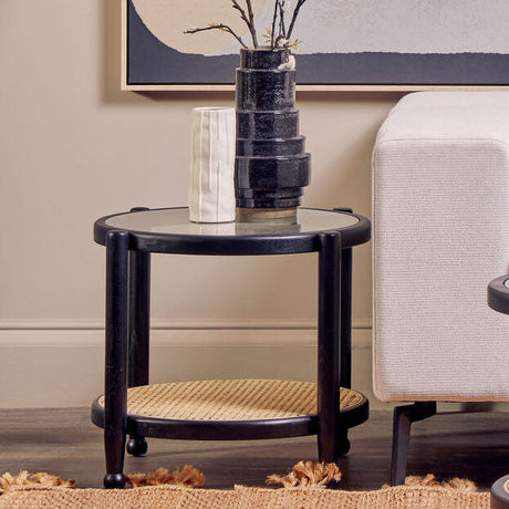 Orsina Side Table in black with a round top and woven base, perfect for modern living spaces
