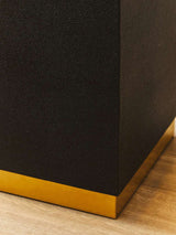 Close-up of Orsina Side Table featuring a textured black surface and a gold base accent