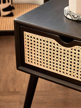 Orsina modern side table featuring a sleek black finish and a stylish cane drawer front
