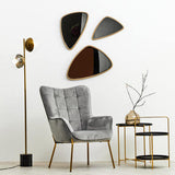 Stylish Orsina side table in gold metal with modern design, displayed beside a grey chair and decorative wall mirrors
