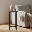 Orsina modern side table in black metal beside a grey couch with cozy knitted throw