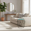 Modern Orsina Side Table with Geometric Design and Glass Top beside a comfortable sofa in a bright living room