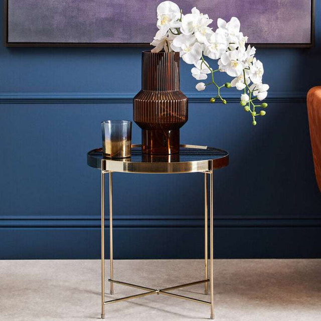 Elegant Orsina Side Table with a sleek black surface and gold legs, styled with a vase and flowers