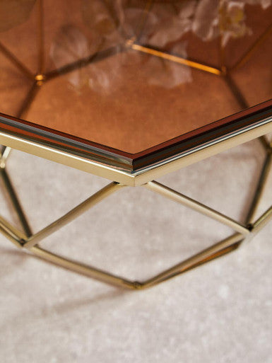 Orsina Side Table with a geometric gold base and a stylish glass top
