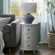 Shades 4 Seasons Round Side Table with three drawers and a stylish lamp in a cosy living room setting