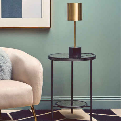 Stylish Orsina Side Table with sleek design and metallic accents beside a cosy armchair