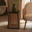 Orsina side table with a wooden top and wicker design, paired with a stylish armchair