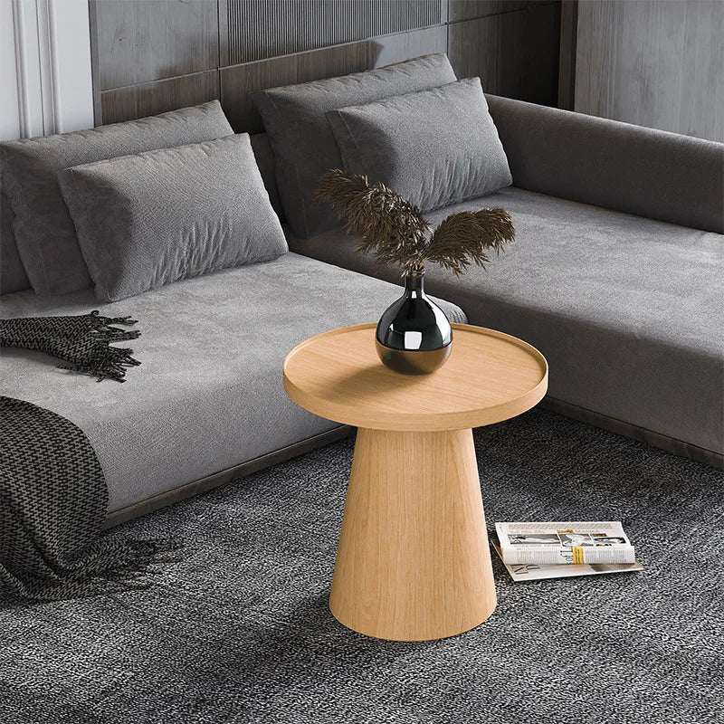 Stylish wooden side table with a rounded top, placed beside a grey sofa in a modern living room