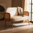 Orsina 2 Seater Sofa in cream with wooden armrests and a cosy blanket draped over it