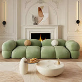 Stylish Nisu Home green sofa with plush cushions and rounded edges in a modern living room setting