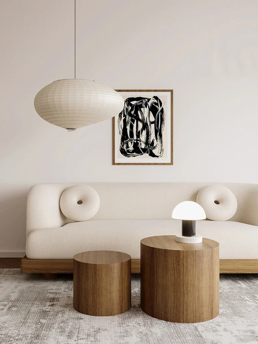 Stylish Nisu Home sofa in cream with rounded buttons and wooden coffee tables in modern living room