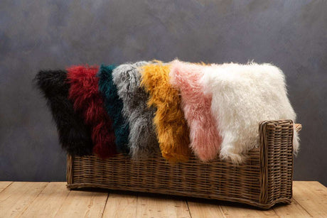 A selection of vibrant Orsina Square Cushions in various colours displayed on a wicker basket