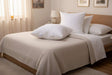 Square Pillow from PillowPillow on a neatly made bed with a beige coverlet