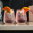 Selbrae House stemless glasses featuring a lion design with refreshing drinks and orange slices
