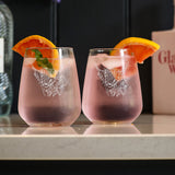 Selbrae House stemless glasses featuring a lion design with refreshing drinks and orange slices