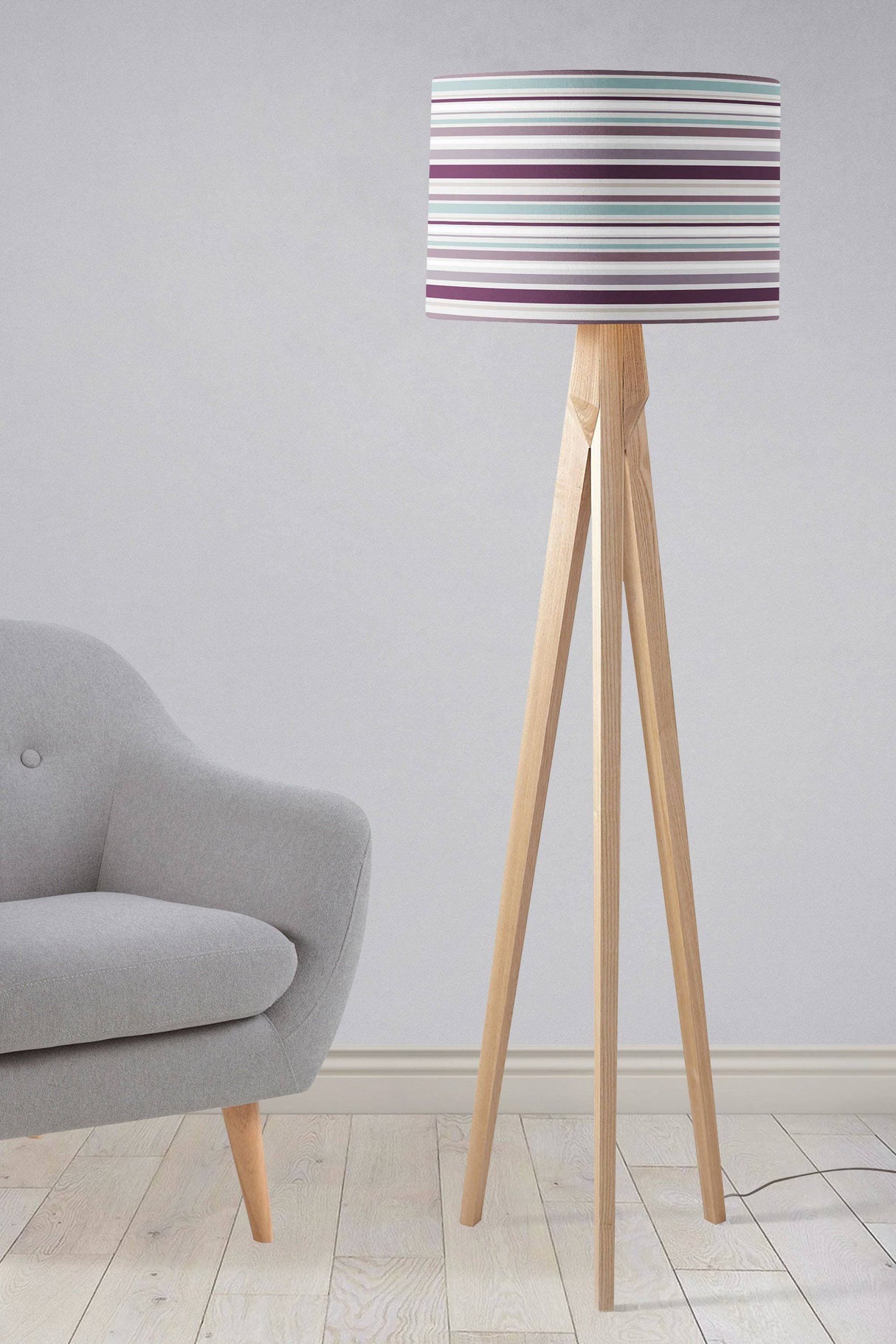 Shadow Bright striped lampshade on a stylish wooden tripod floor lamp in a modern living room setting