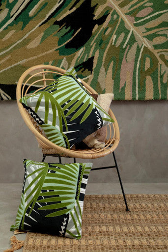 Orsina Striped Rug paired with tropical cushions in a stylish living room setting