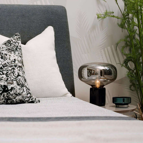 Stylish Nisu Home Table Lamp in a modern setting, complementing decorative cushions on a bed