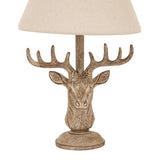 Rustic table lamp with a deer head base and neutral fabric shade for a charming accent