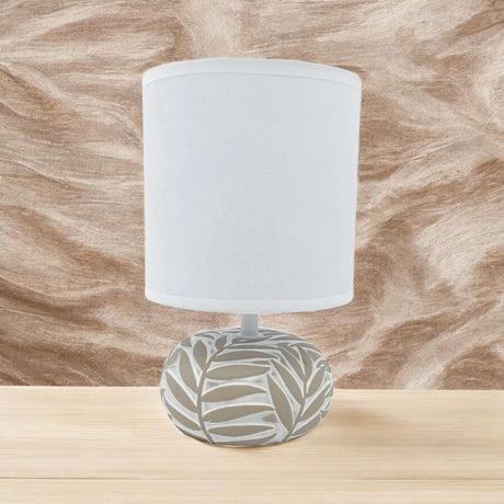 Stylish table lamp with a decorative leaf pattern base and a white shade for modern interiors