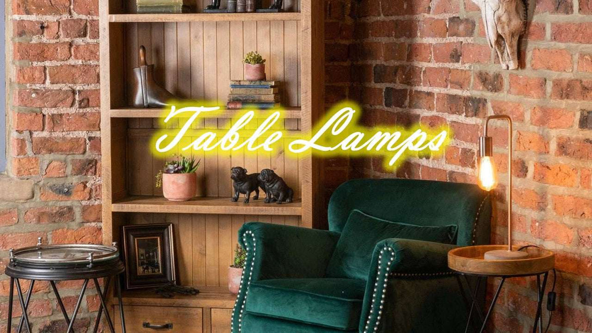 Stylish Orsina Table Lamp on a wooden side table next to a green velvet chair in a rustic setting